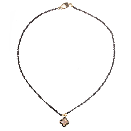 Colier fin din hematit, turmalină și sidef, cu pandantiv trifoi în tonuri aurii și accente elegante de negru – bijuterie handmade cu design minimalist și simbolistică subtilă.